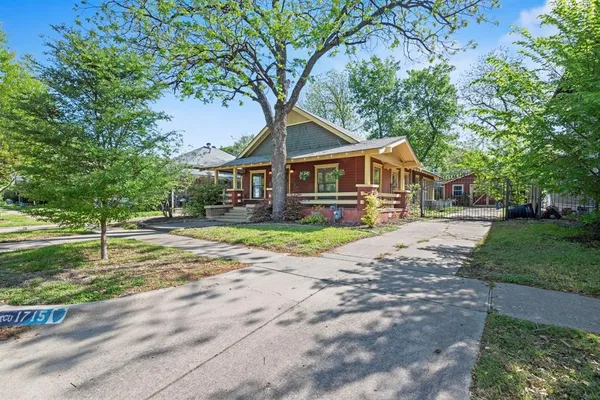 a front view of a house with a yard and green space