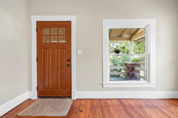 an empty room with wooden floor and a window