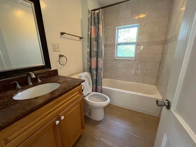 a bathroom with a granite countertop sink toilet and shower