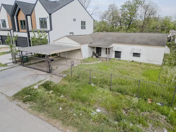 a aerial view of a house with table and chairs under an umbrella