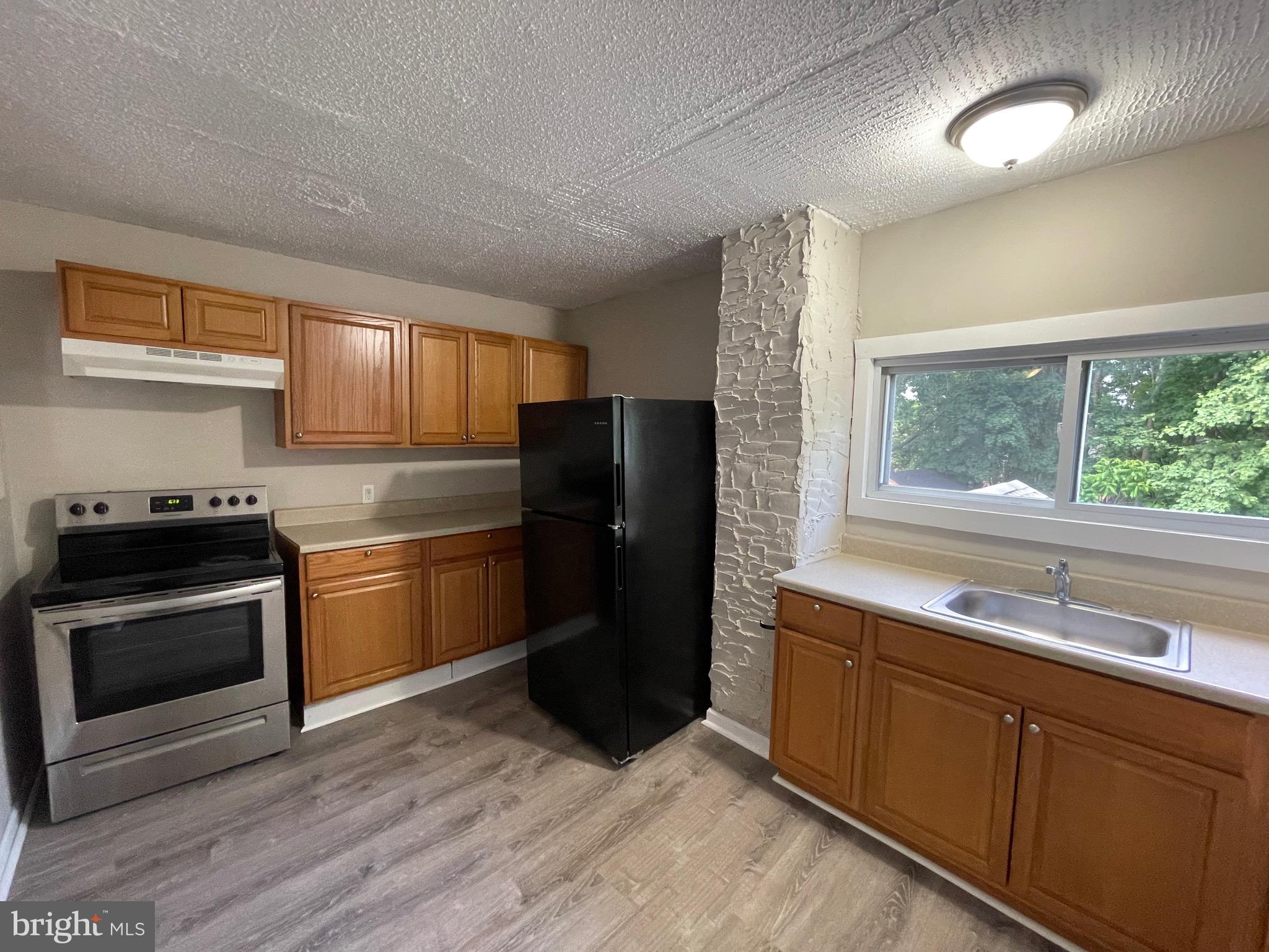382 East Broadway, Unit 2 Salem, NJ 08079 - Photo 1 of 6 a kitchen with a refrigerator and a sink