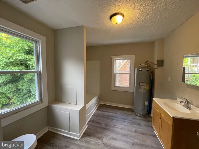 a bathroom with a sink mirror and window