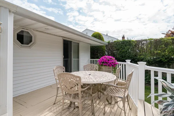 a view of a deck with a table and chairs with wooden floor and fence