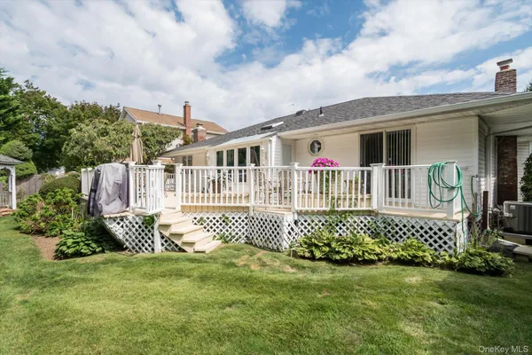 a view of a house with wooden deck and furniture