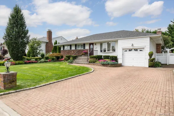 a front view of a house with a yard and potted plants