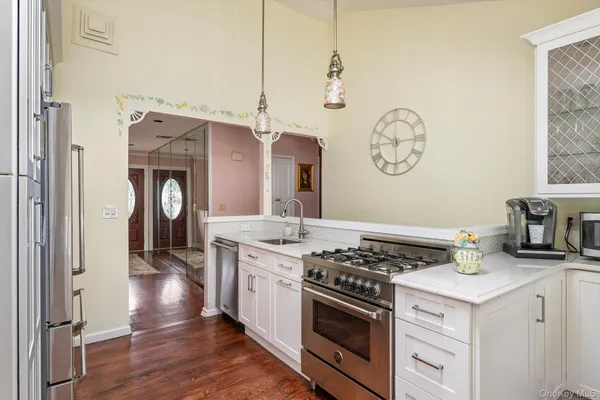 a kitchen with stainless steel appliances granite countertop a stove and a wooden floors