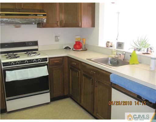 25 Woodbury Road Edison, NJ 08820 - Photo 4 of 8 a kitchen with stainless steel appliances a stove and a microwave