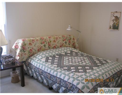 25 Woodbury Road Edison, NJ 08820 - Photo 6 of 8 a bedroom with a bed and a table