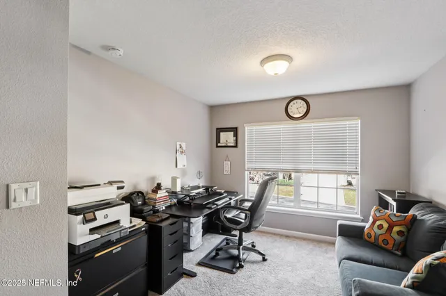 a view of a livingroom with workspace and a window