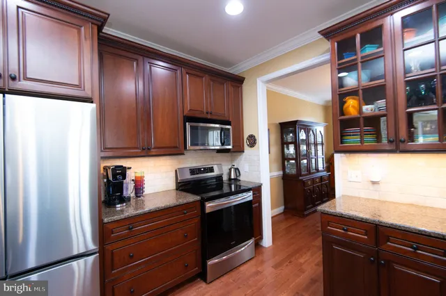 a kitchen with stainless steel appliances granite countertop a refrigerator microwave and stove top oven