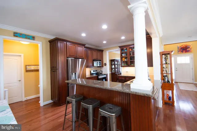 a kitchen with stainless steel appliances granite countertop a refrigerator stove top oven and sink