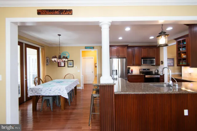 a kitchen with stainless steel appliances granite countertop a refrigerator and a wooden cabinets