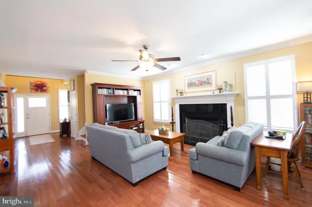 a dining room with wooden floor a chandelier a wooden table and chairs