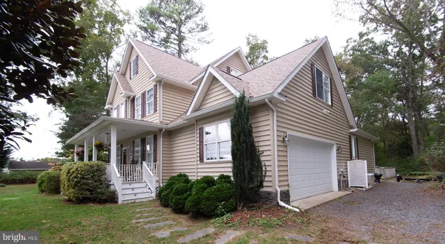 a front view of a house with a garden and plants