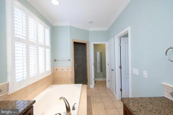 a bathroom with a tub a sink and a window
