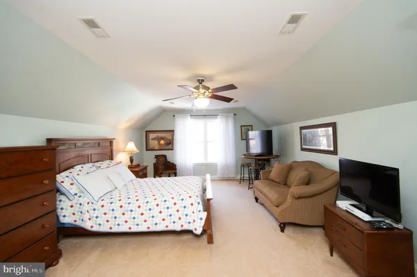 a bedroom with a large bed couch and window