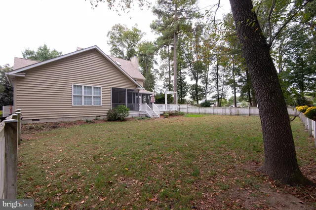 a view of a yard in front of a house with large tree