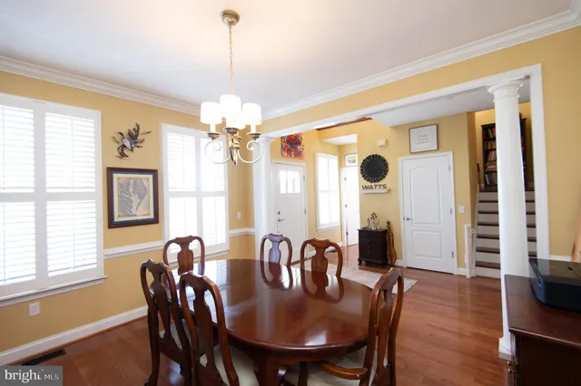 a dining room with furniture a chandelier and wooden floor