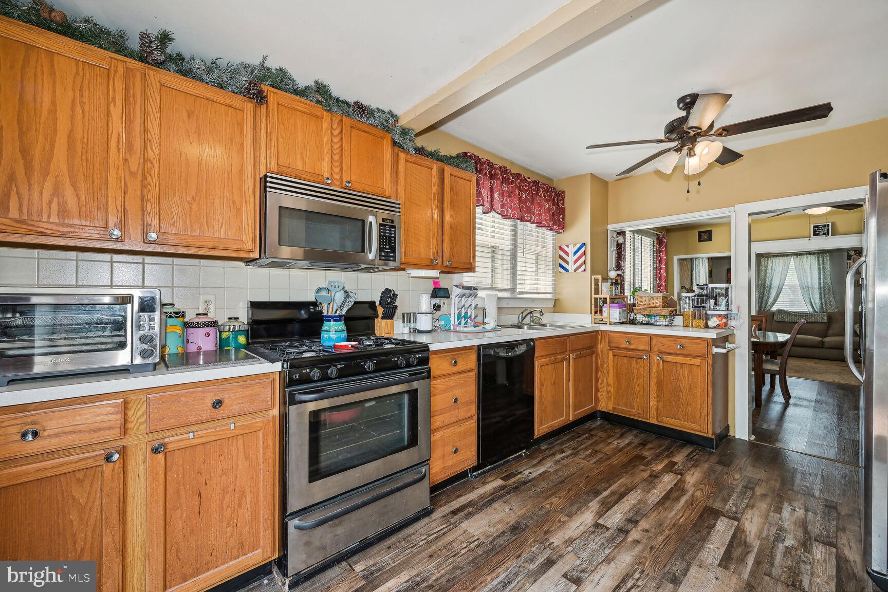 48 Haverford Road Runnemede, NJ 08078 - Photo 12 of 23 a kitchen with granite countertop a stove top oven a sink dishwasher and white cabinets with wooden floor