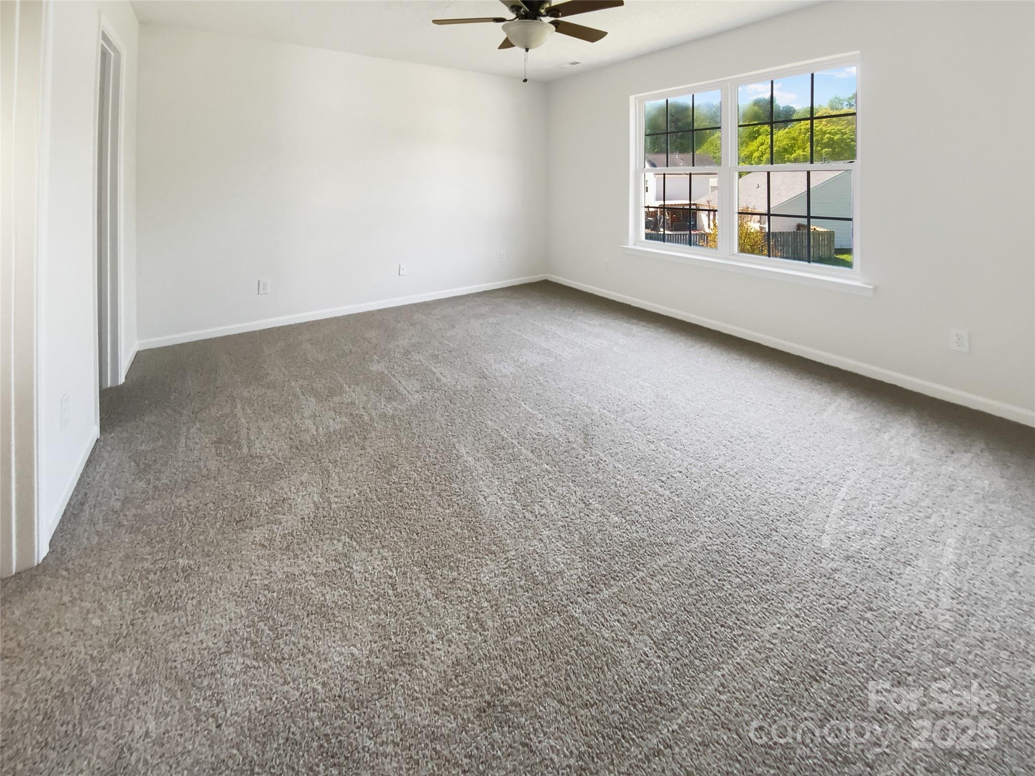 4437 Devonhill Lane Charlotte, NC 28269 - Photo 13 of 18 an empty room with windows and chandelier fan