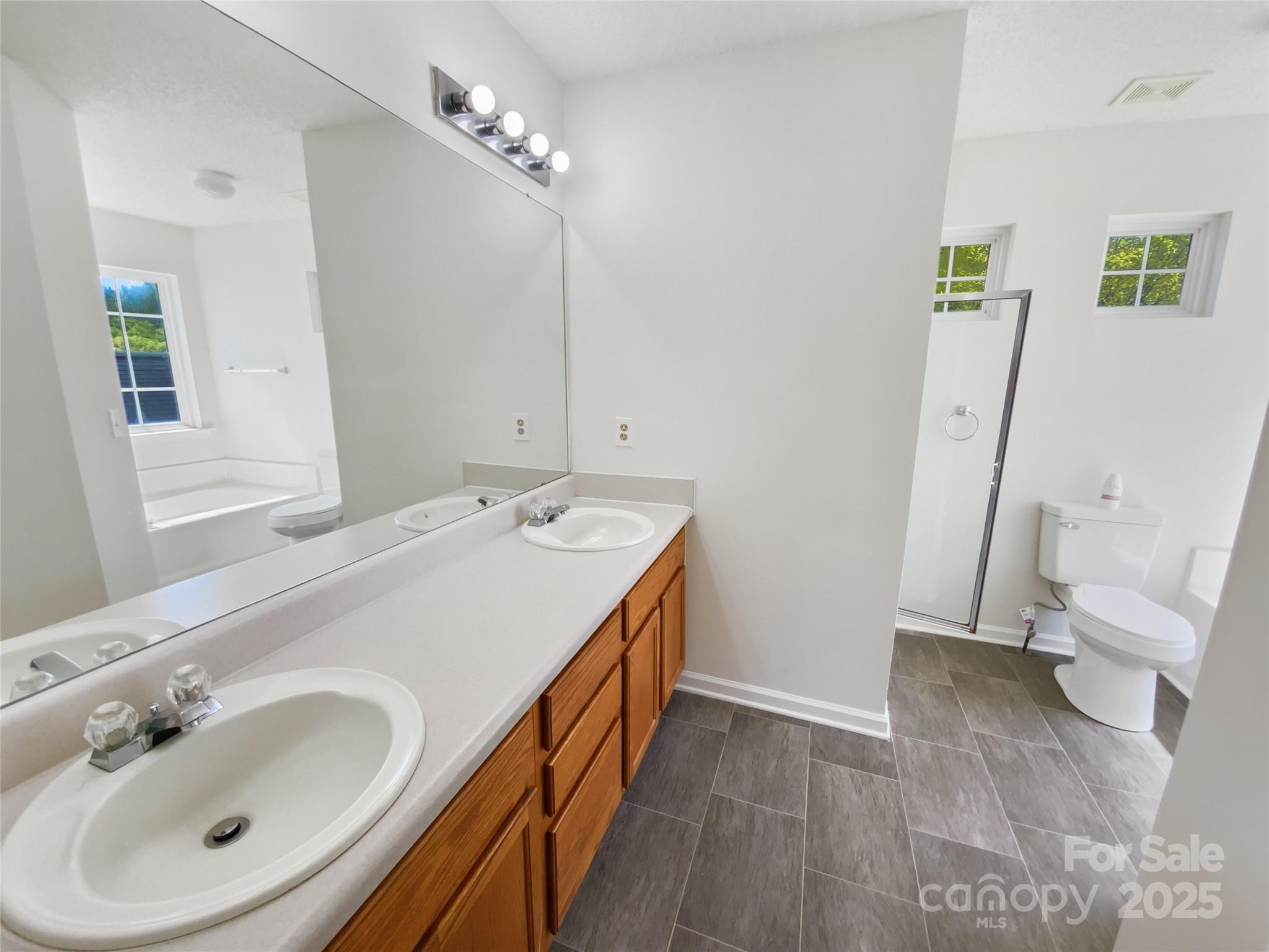 4437 Devonhill Lane Charlotte, NC 28269 - Photo 7 of 18 a bathroom with a sink a toilet and a mirror