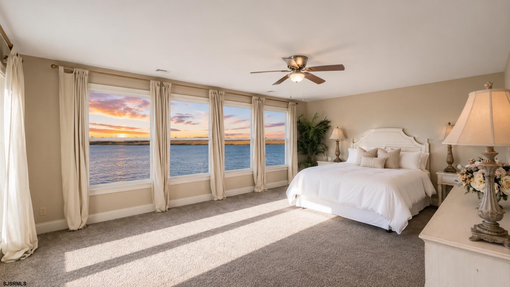 2070 West Riverside Drive Atlantic City, NJ 08401 - Photo 16 of 40 a spacious bedroom with a large bed and a chandelier fan