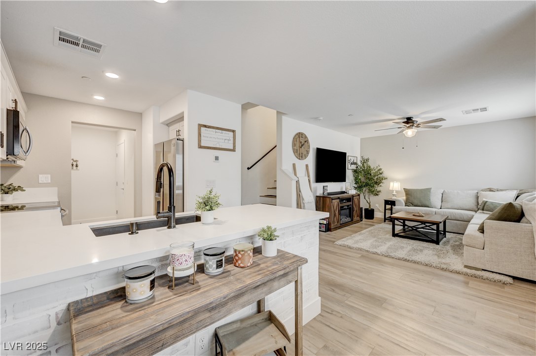 12106 Azure Gate Road, Unit 3 Las Vegas, NV 89183 - Photo 76 of 77 Kitchen featuring a peninsula, white cabinetry, light wood-type flooring, stainless steel appliances, and open floor plan