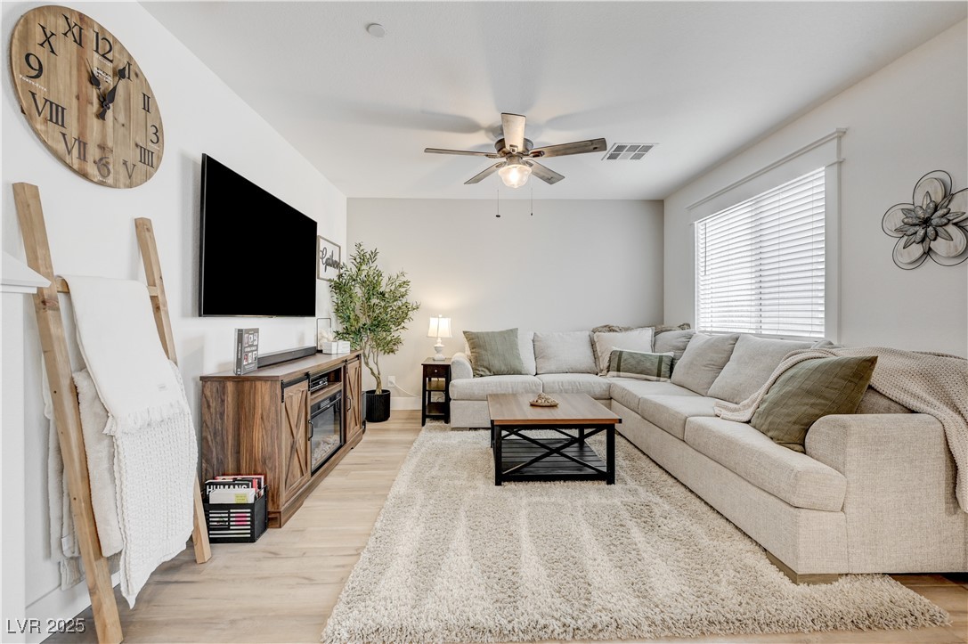 Living room with a ceiling fan and light wood-style flooring
