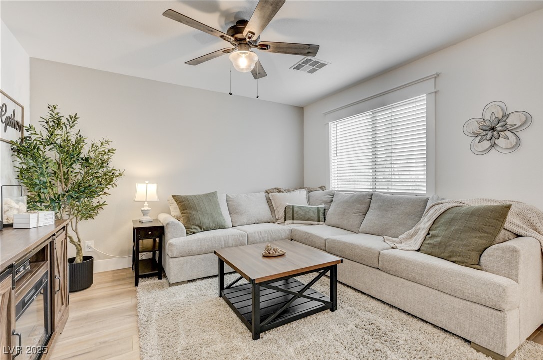 Living area featuring light wood-style floors and ceiling fan