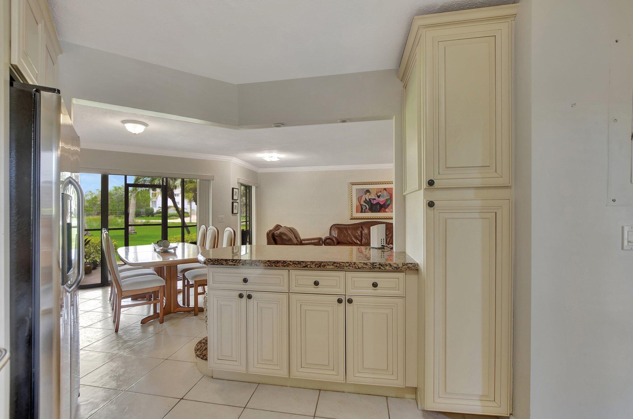 5901 Camino Del Sol, Unit 107 Boca Raton, FL 33433 - Photo 14 of 51 a kitchen with a sink and chairs