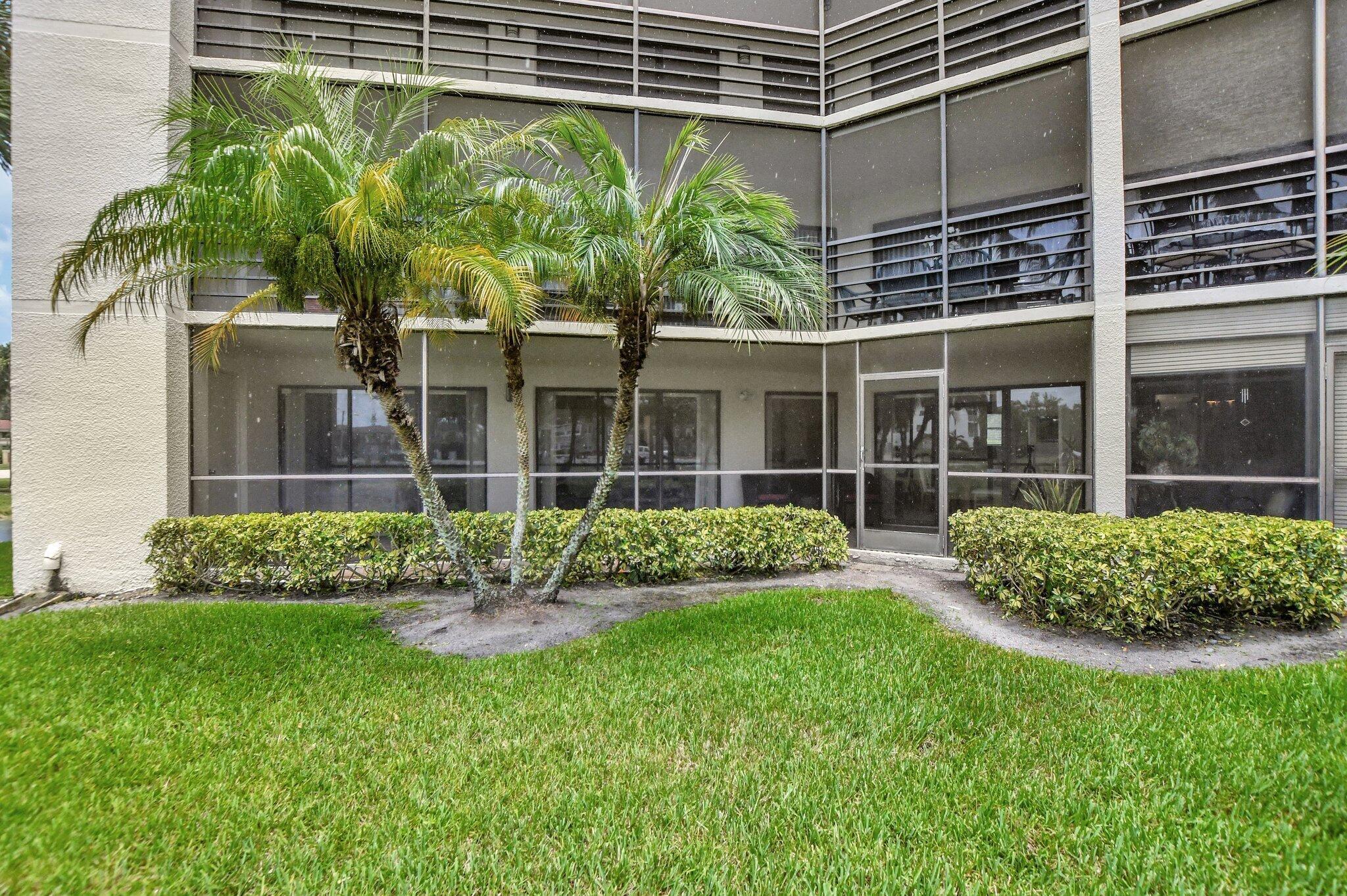 5901 Camino Del Sol, Unit 107 Boca Raton, FL 33433 - Photo 18 of 51 a view of a house with a yard and a garden