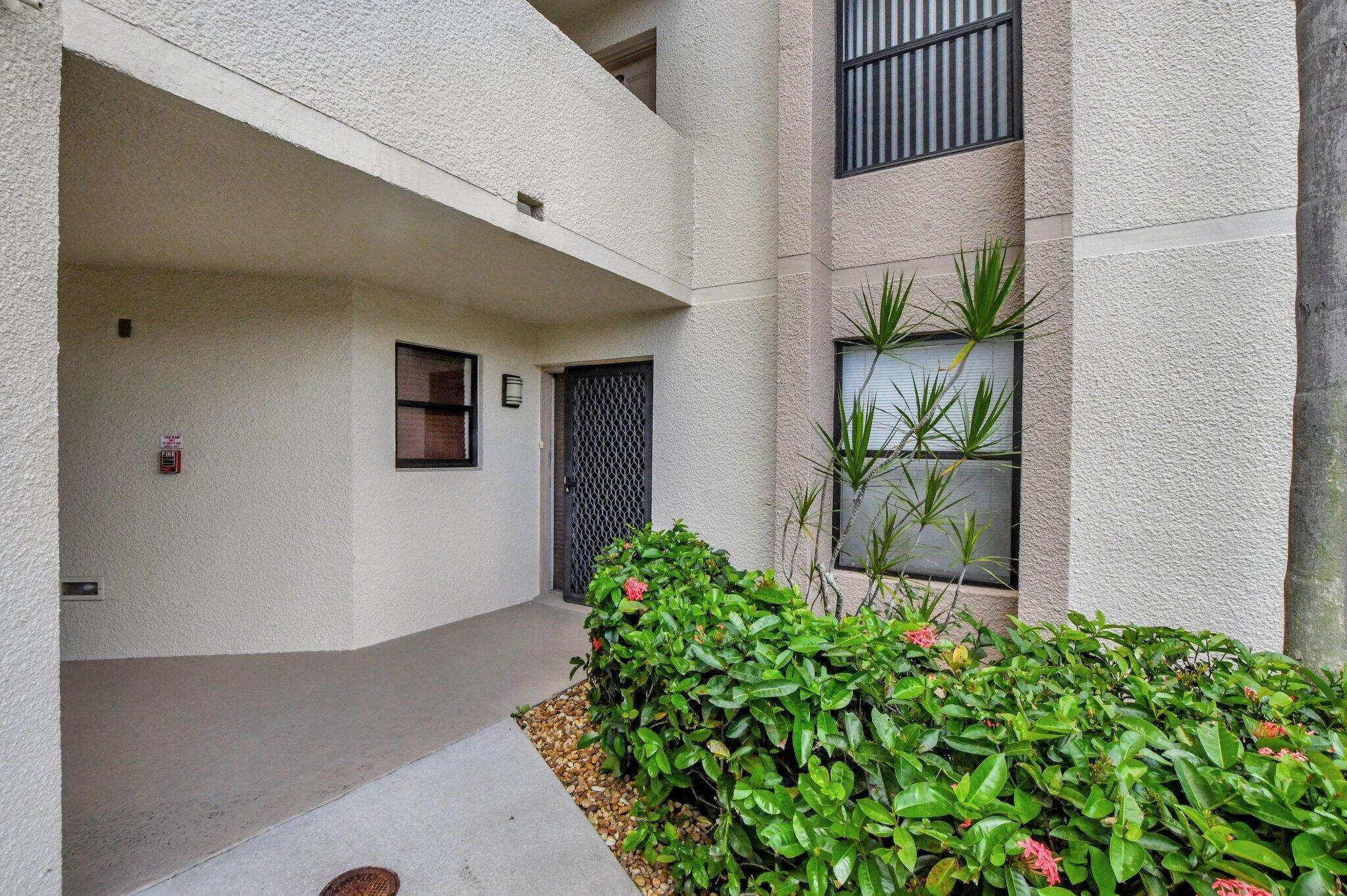 5901 Camino Del Sol, Unit 107 Boca Raton, FL 33433 - Photo 2 of 51 a front view of a house with garden
