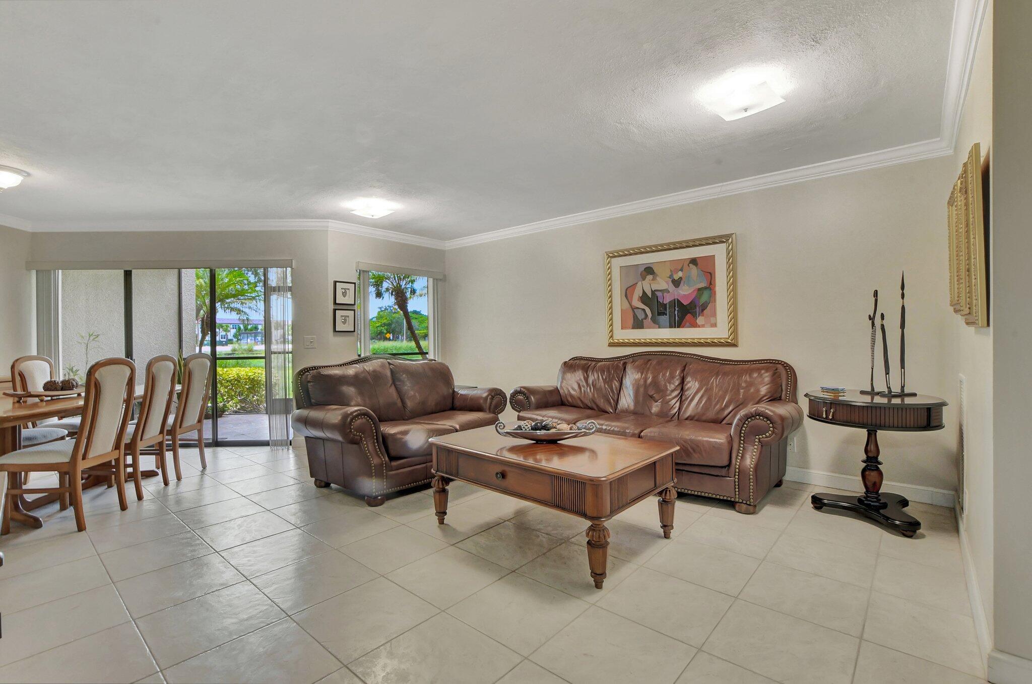 5901 Camino Del Sol, Unit 107 Boca Raton, FL 33433 - Photo 3 of 51 a living room with furniture and a large window