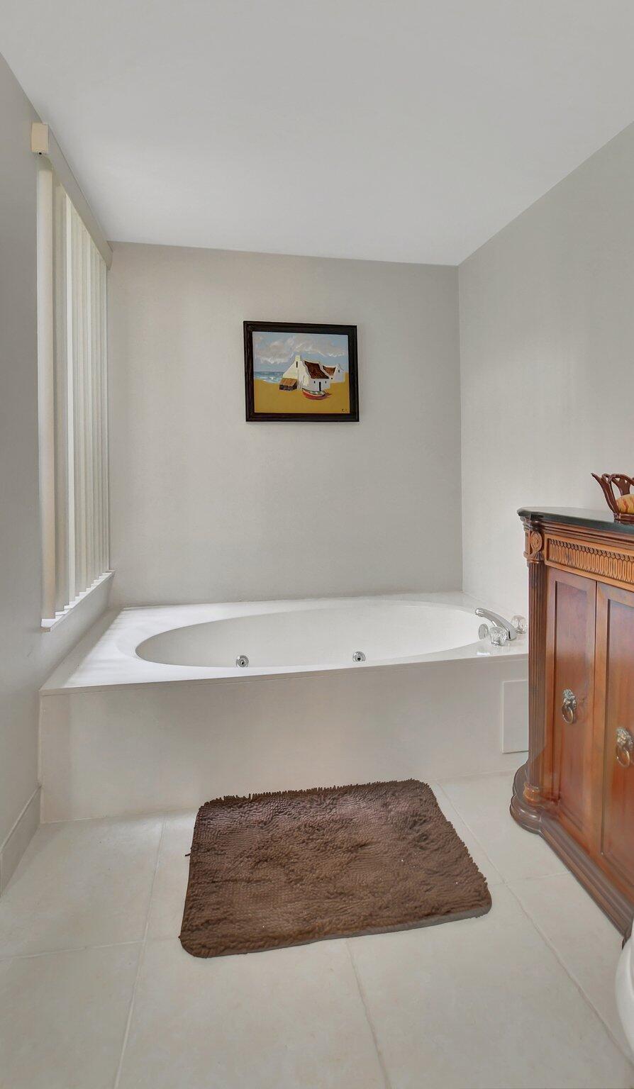 5901 Camino Del Sol, Unit 107 Boca Raton, FL 33433 - Photo 32 of 51 a bathroom with a bathtub and shower
