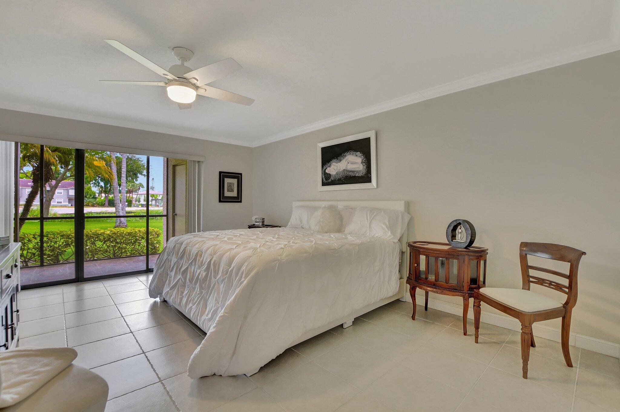 5901 Camino Del Sol, Unit 107 Boca Raton, FL 33433 - Photo 34 of 51 a bed room with a bed and a chandelier
