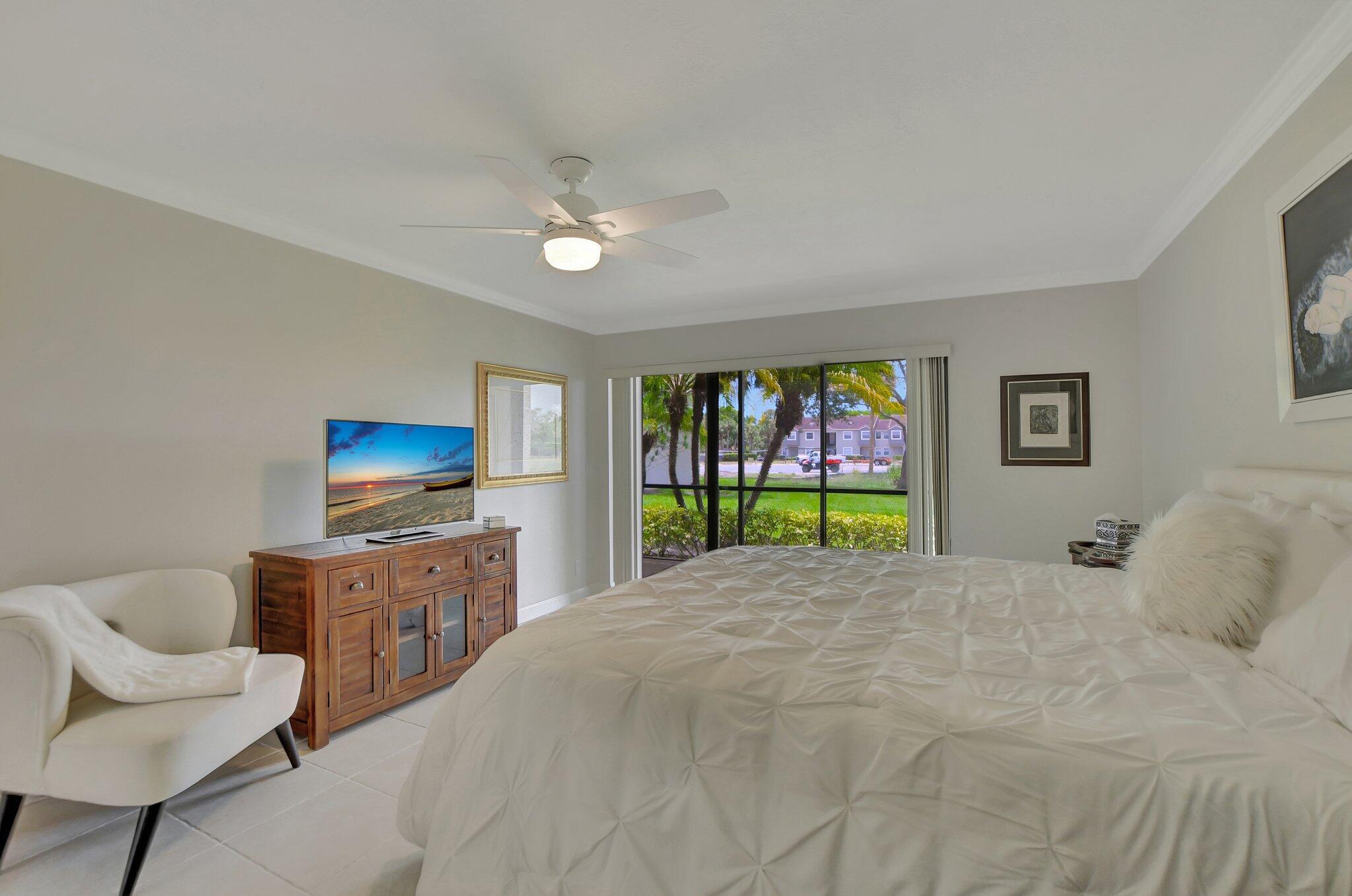 5901 Camino Del Sol, Unit 107 Boca Raton, FL 33433 - Photo 35 of 51 a bed room with a bed a television and a couch
