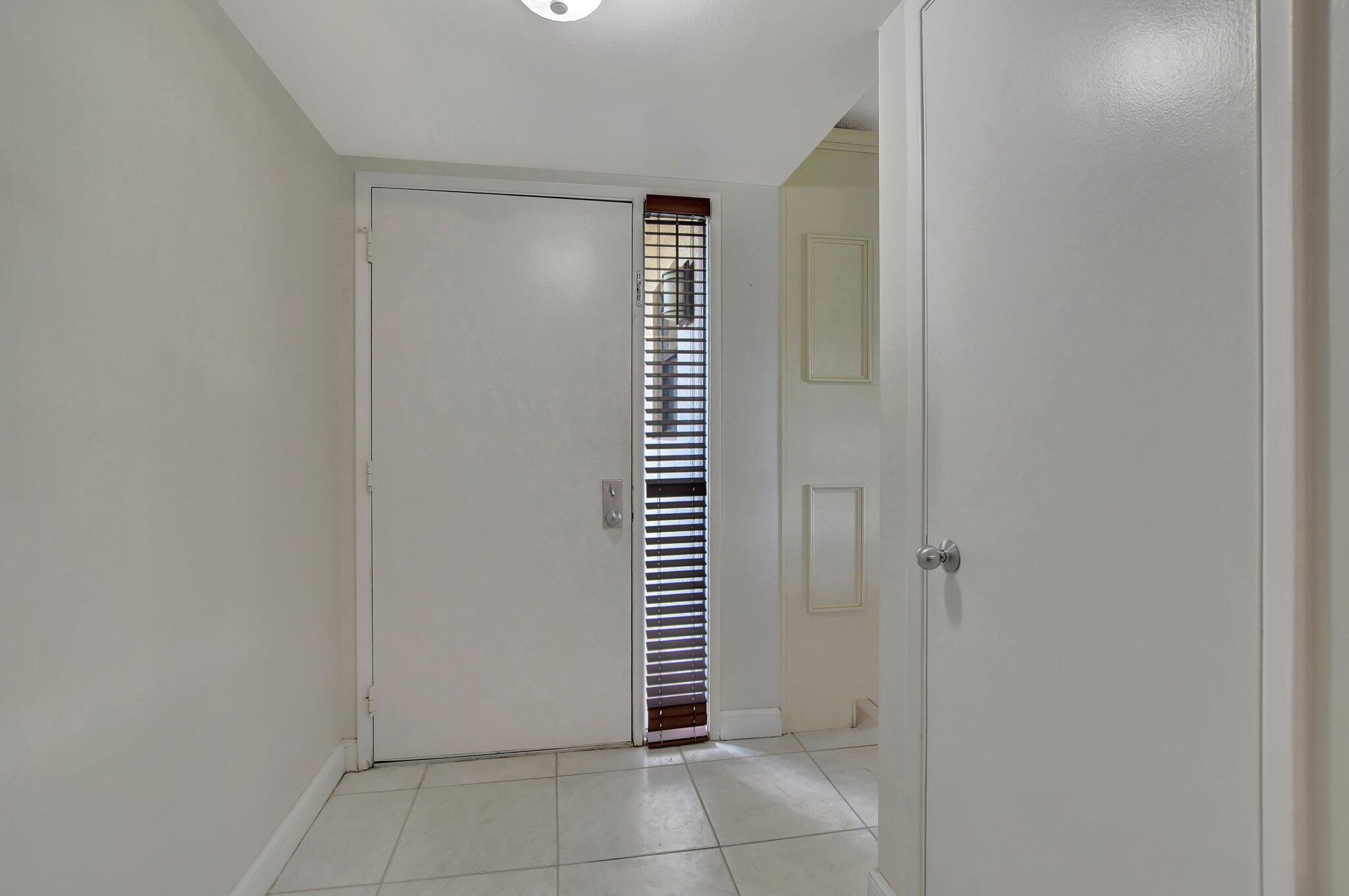 5901 Camino Del Sol, Unit 107 Boca Raton, FL 33433 - Photo 5 of 51 a view of an empty room with a white cabinet