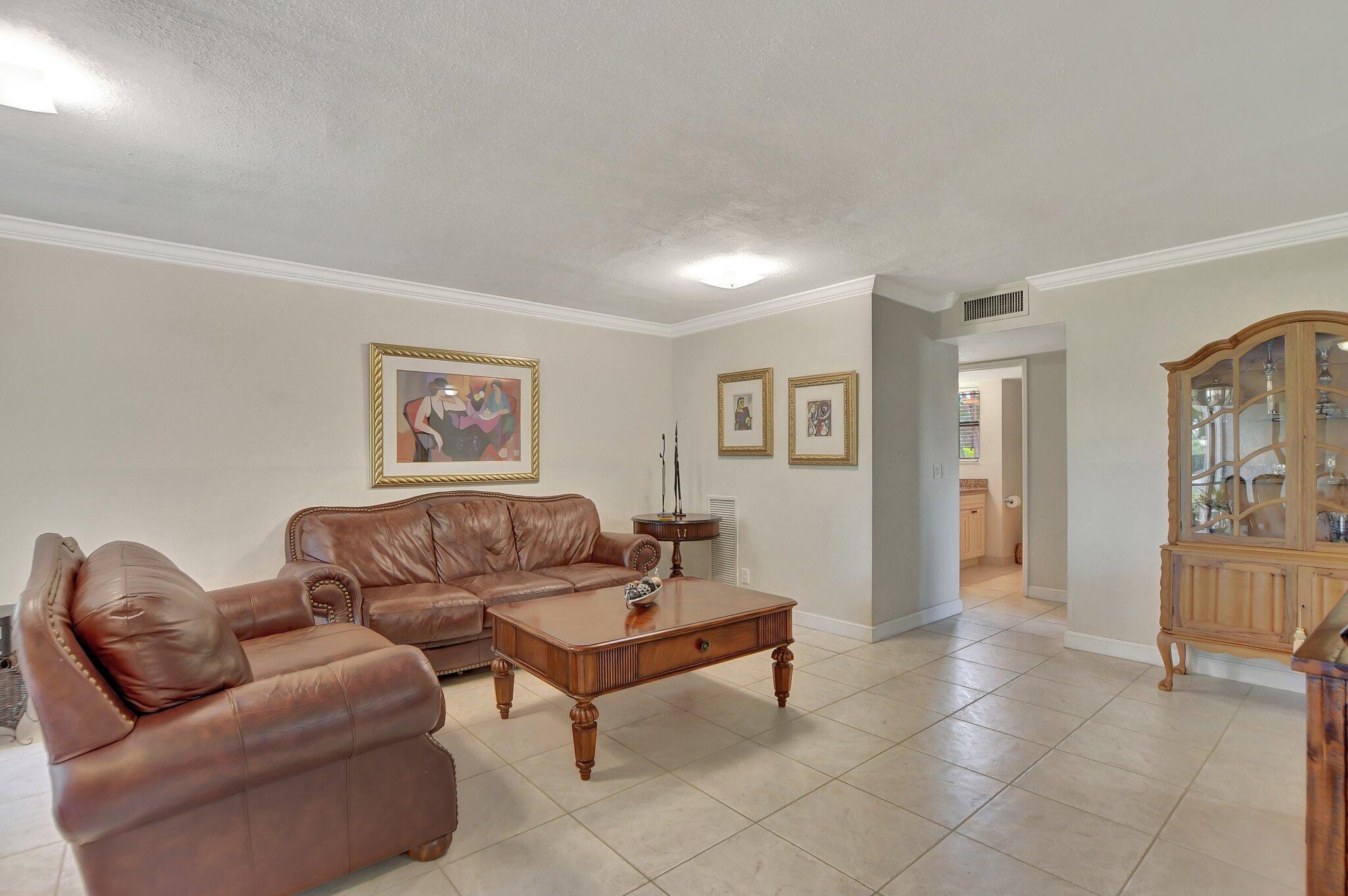 5901 Camino Del Sol, Unit 107 Boca Raton, FL 33433 - Photo 7 of 51 a living room with furniture and a wooden floor