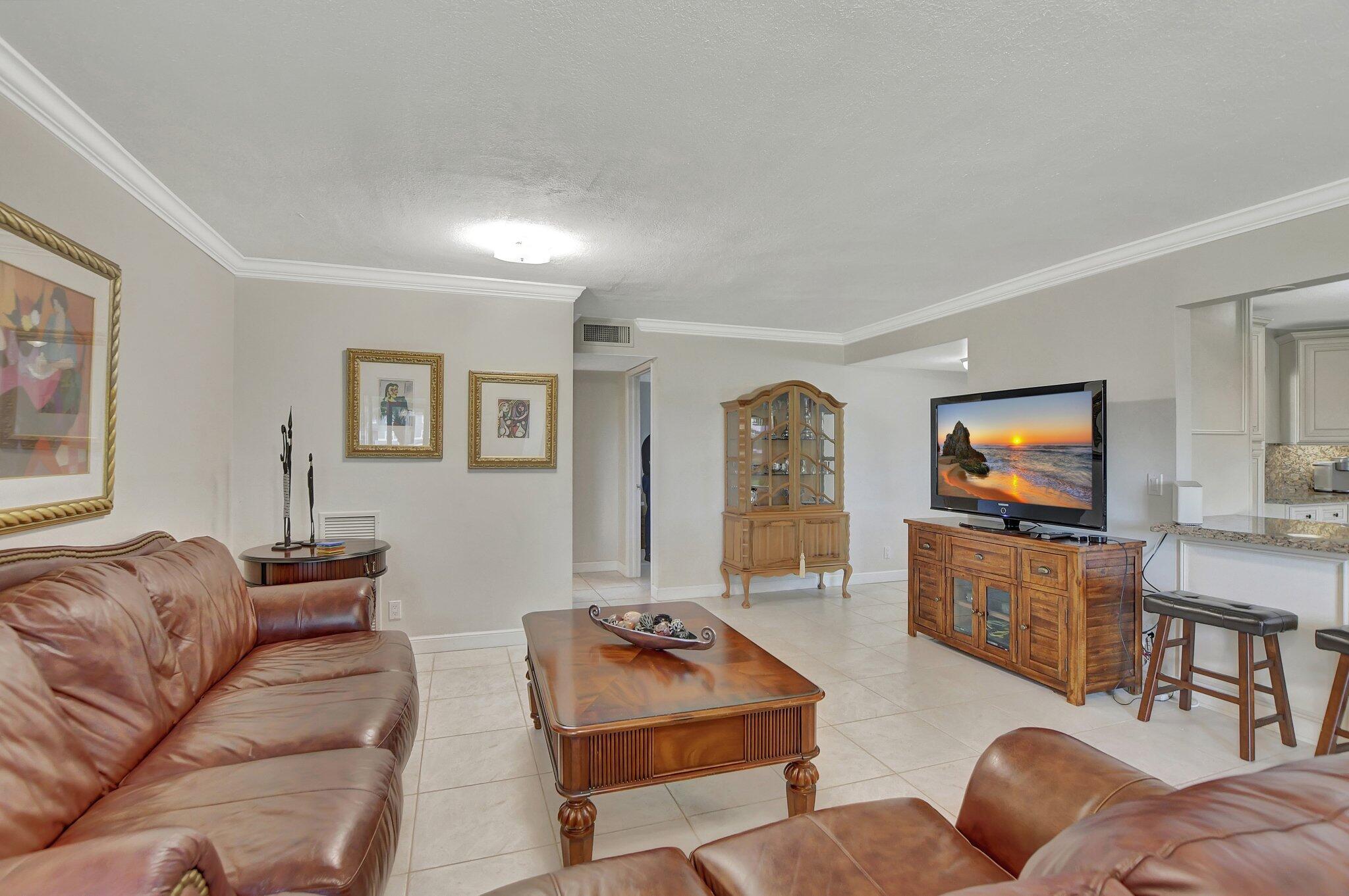 5901 Camino Del Sol, Unit 107 Boca Raton, FL 33433 - Photo 8 of 51 a living room with furniture and a flat screen tv