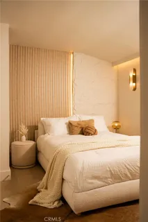 a bedroom with a bed and a painting on the wall