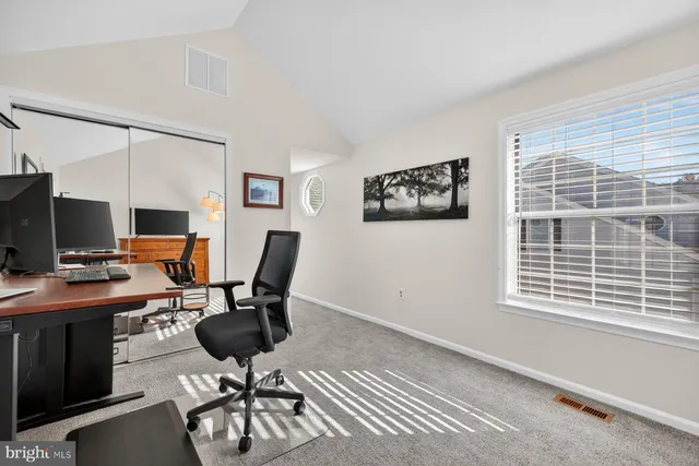 a view of a workspace with furniture and a window