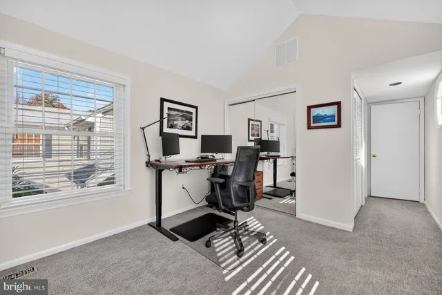 a view of a workspace with furniture and a window