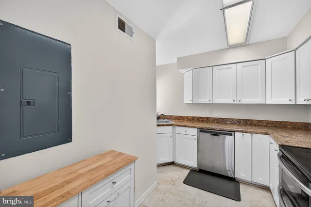 a kitchen with granite countertop white cabinets and white appliances