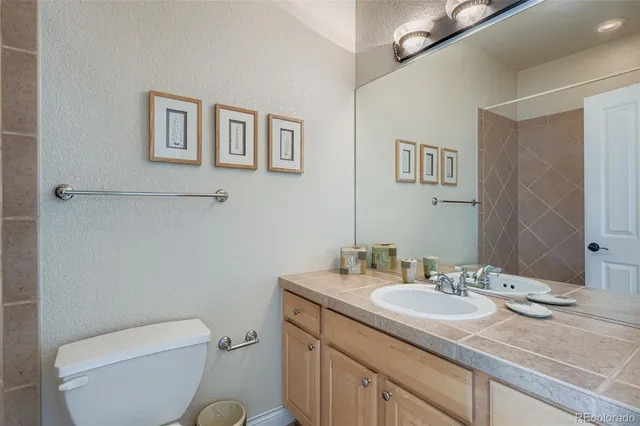 a bathroom with a granite countertop toilet sink and mirror