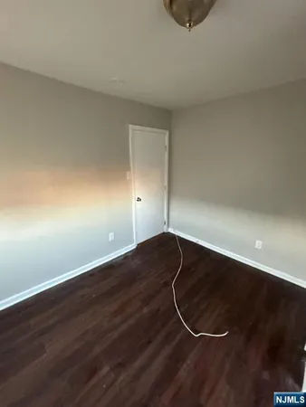 a room with wooden floor and white walls