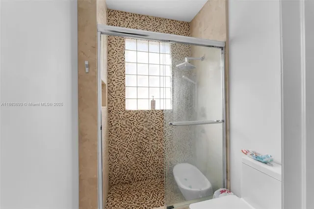 a bathroom with a toilet and a shower
