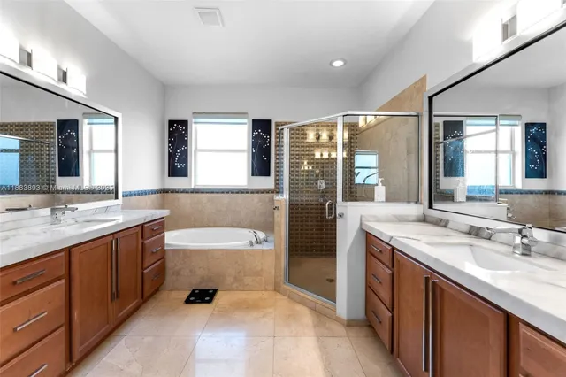 a spacious bathroom with a tub double sink and mirror