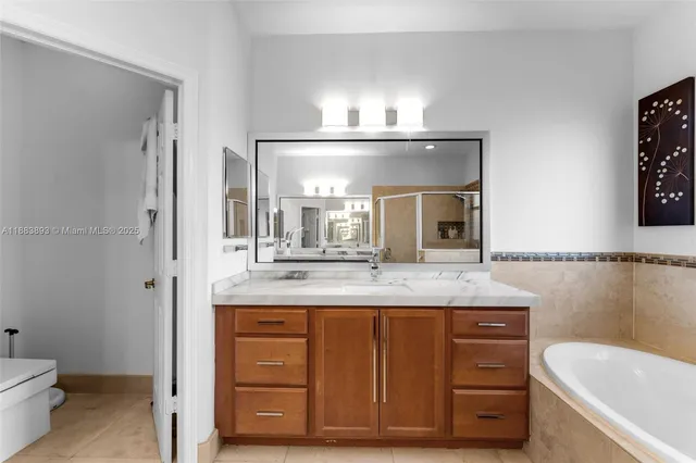 a bathroom with a granite countertop sink a mirror and a toilet