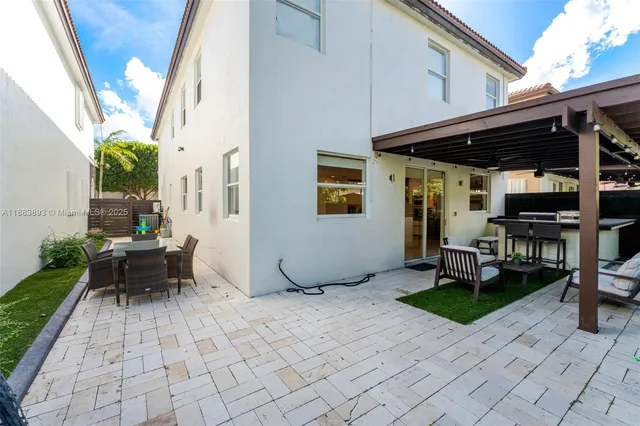 a backyard of a house with barbeque oven table and chairs