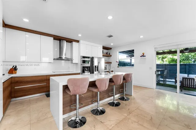 a kitchen with stainless steel appliances kitchen island granite countertop a sink and cabinets